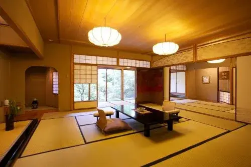 Ryotei Hanzuiryo tatami room with lacquer table, paper lanterns, and cedar forest beyond shoji screens