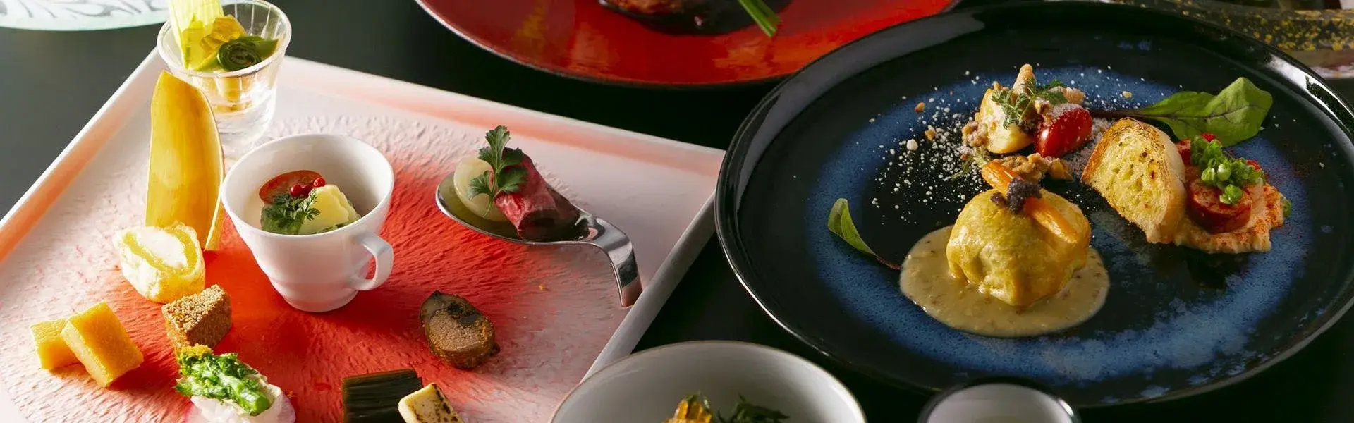 Kaiseki dinner spread across lacquerware and dark ceramic at Yufuin Rokka