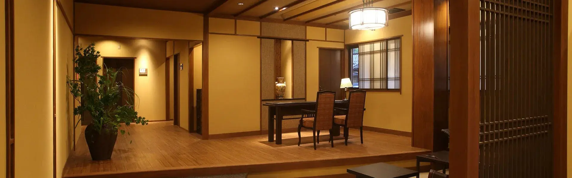 Warmly lit lobby corridor with wood paneling and writing desk at Kokorian