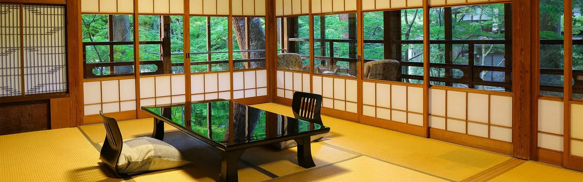 Shoji-screened tatami room with lacquer table and garden views at Kansuirou