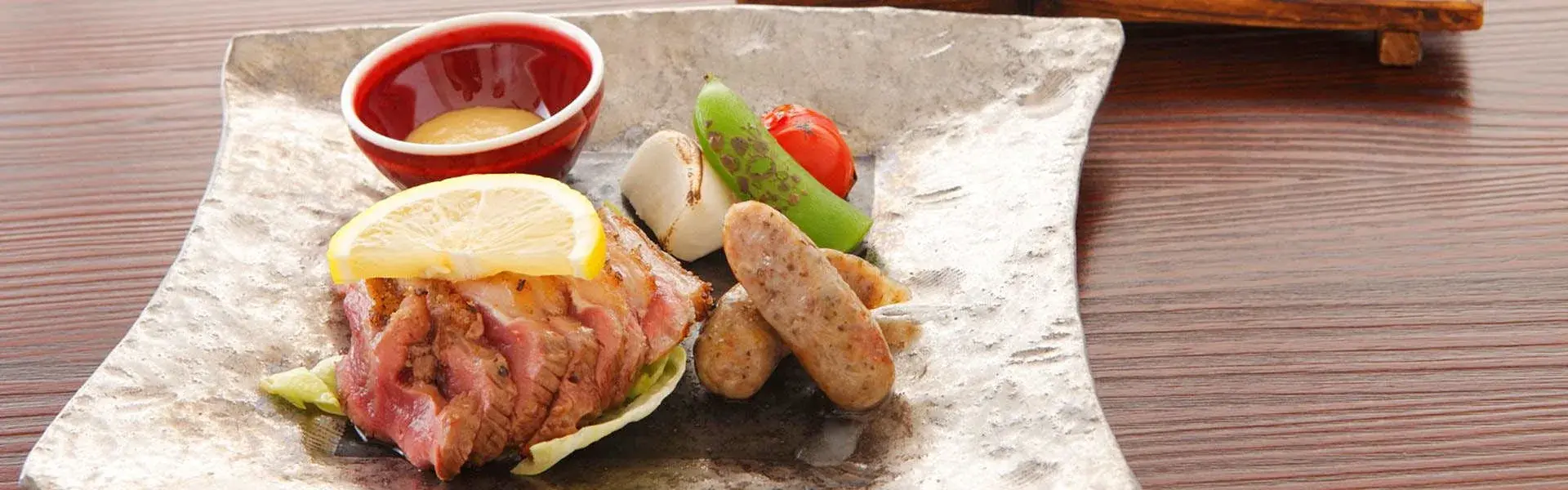 Wagyu beef and herb sausage kaiseki course on hammered silver ceramic