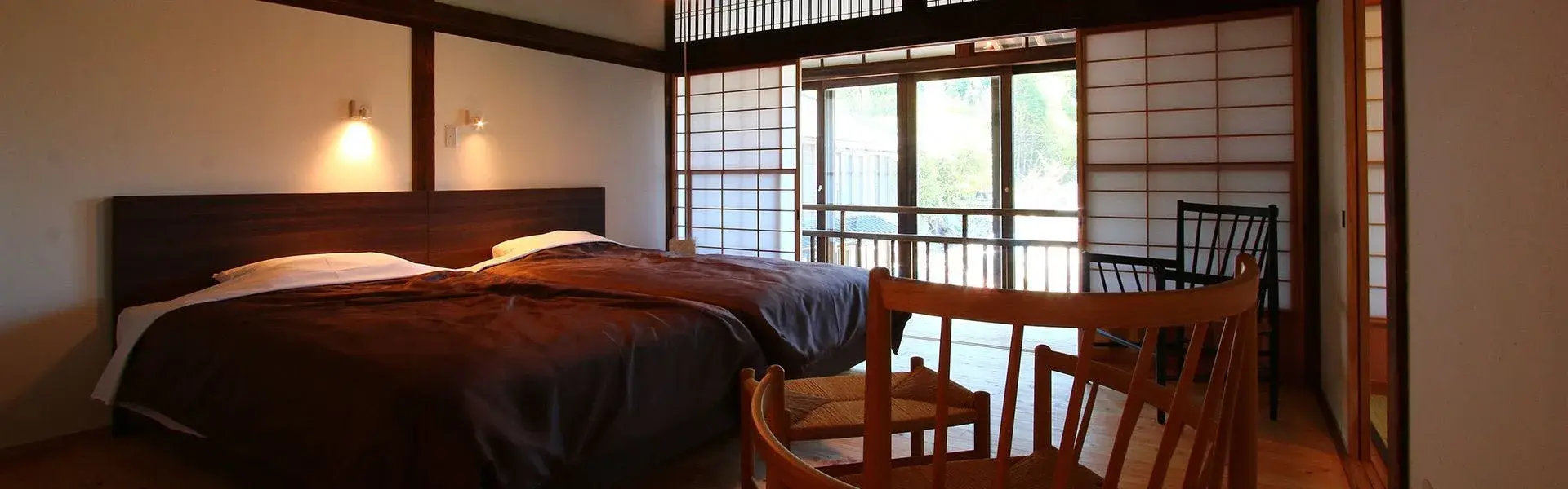 Warm-lit ryokan room with shoji screens and double bed at Seifuso