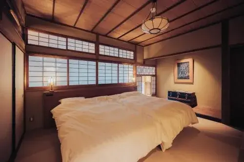 Bedroom suite with shoji screens and exposed timber ceiling at Tocen Goshoboh