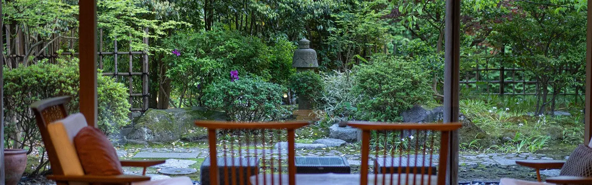 Yume-ya's garden terrace with stone lantern and lush summer foliage