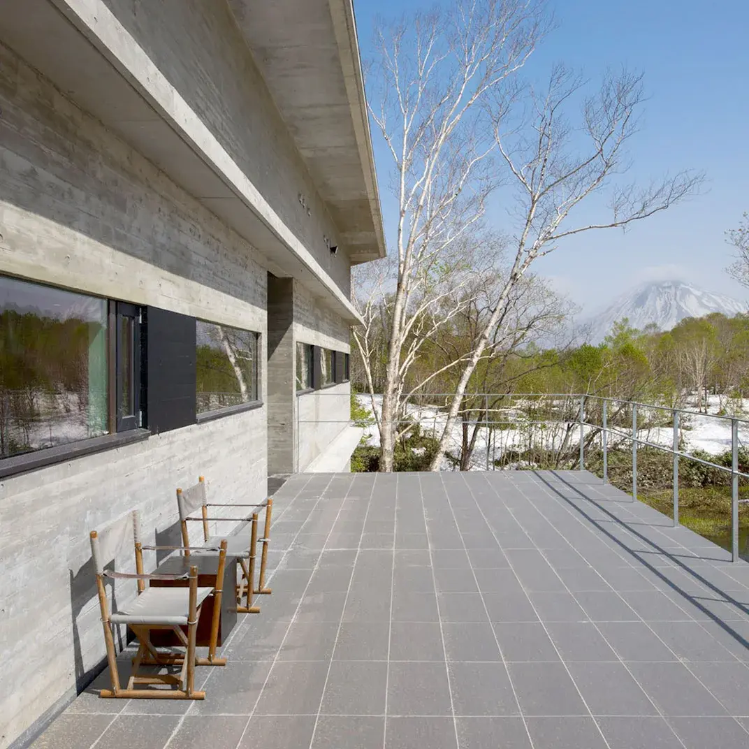 Zaborin's raw concrete terrace overlooking Mt. Yotei and snow-dusted birch forest in Niseko