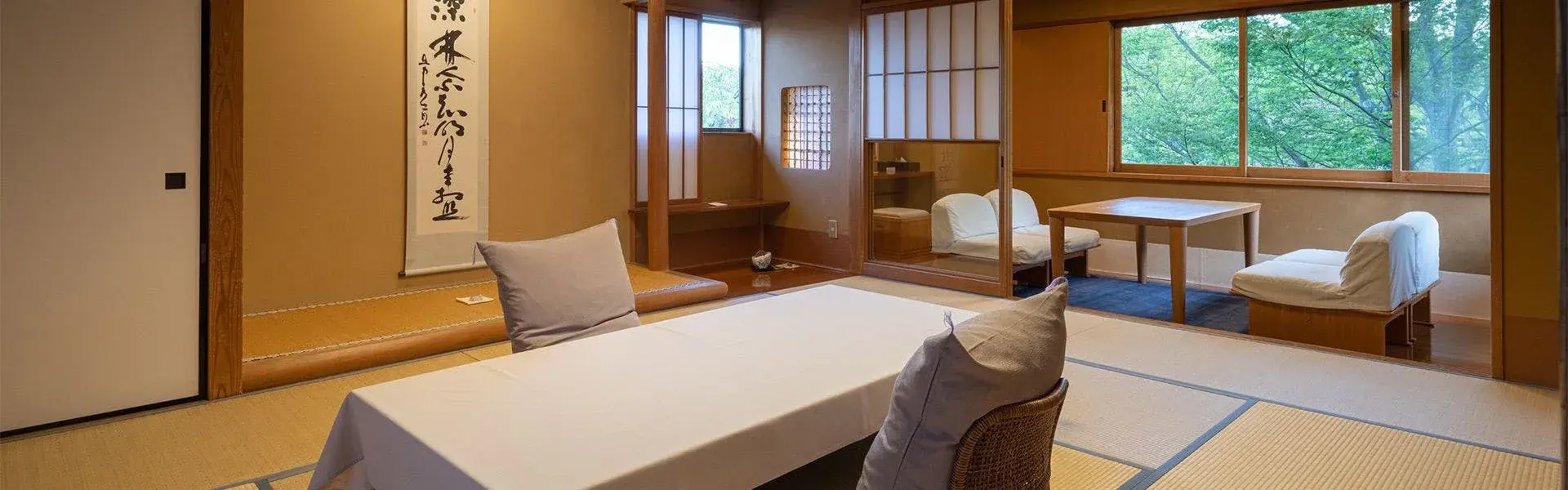 Tatami room with calligraphy scroll and shoji screens at Shaga no Sato Yume-ya