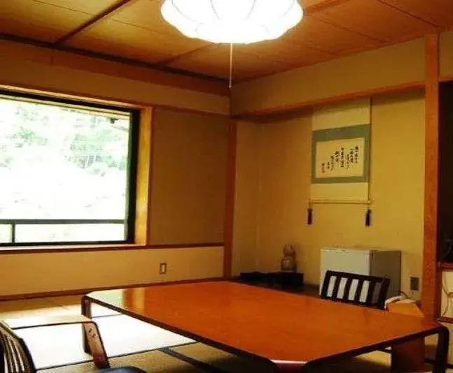 Tatami room at Daimaru Ryokan with calligraphy scroll and river-view window