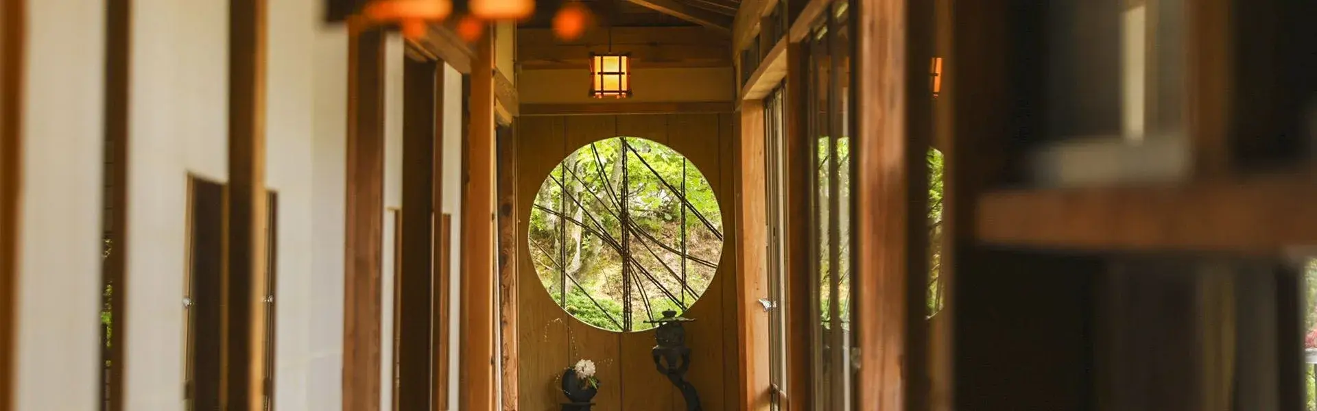 Cedar corridor framing a circular moon window, Fukujyuin Takei Ryokan in Togakushi