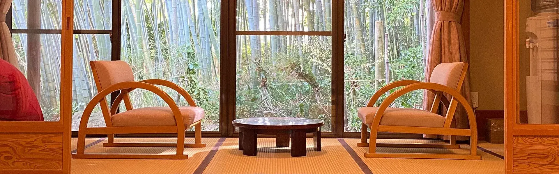 Arc-wood chairs facing a bamboo grove in a Takashimaya tatami sitting room
