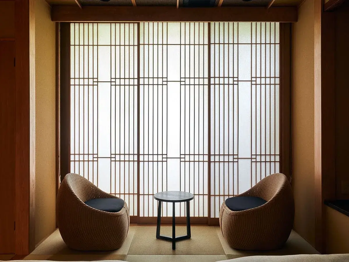 Woven rattan chairs beside shoji screens in a tatami room at Hiyama