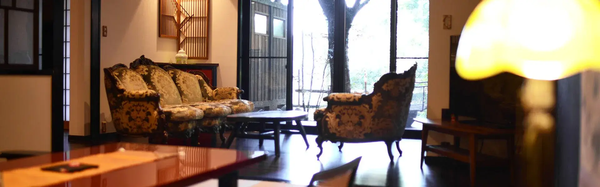 Antique Western-style sofa and armchair in the ryokan lounge, shoji screens behind