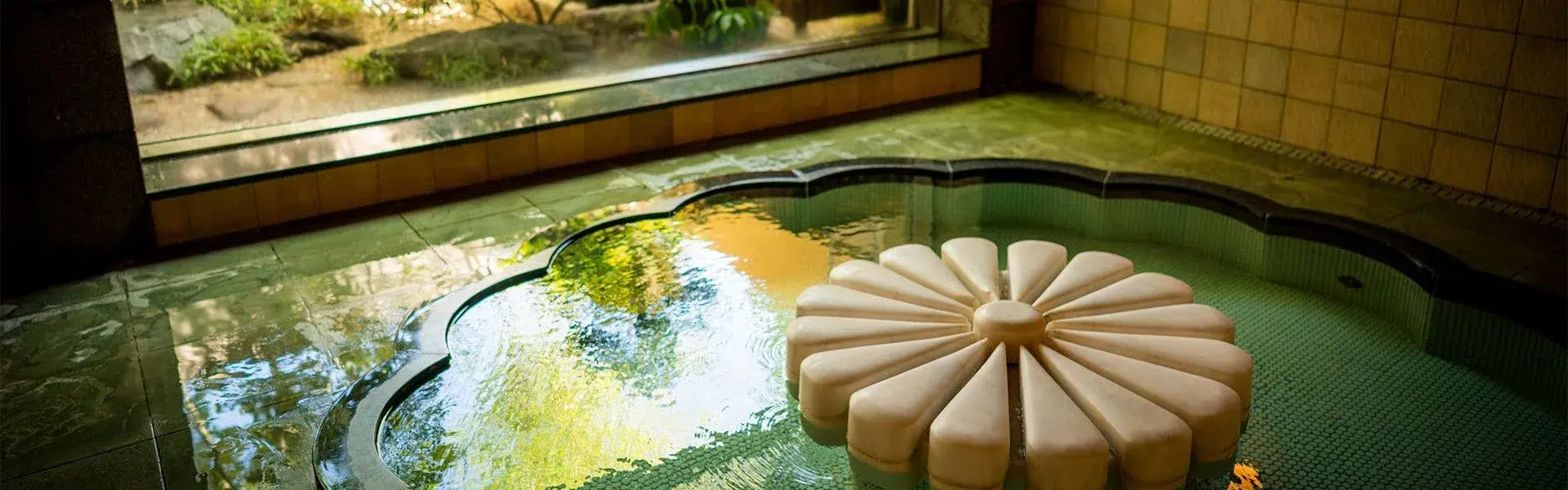 Kikunoyu's chrysanthemum stone float in the green-tiled indoor onsen bath at Asama Onsen