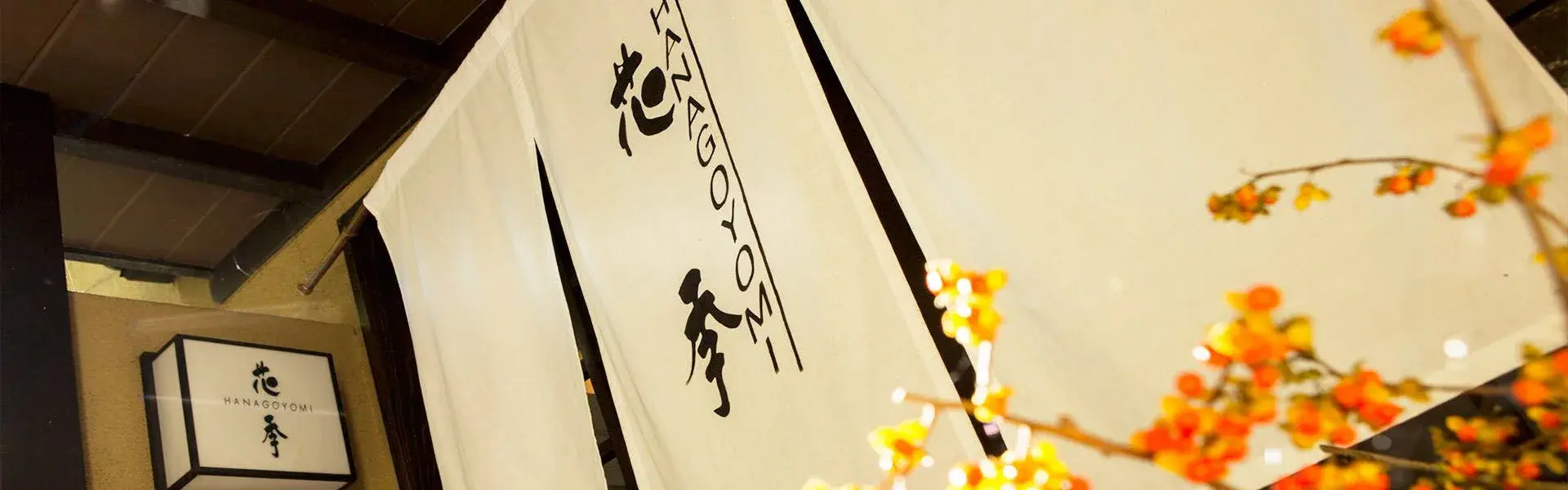 Auberge Hanaki's entrance noren with brushed calligraphy and autumn foliage