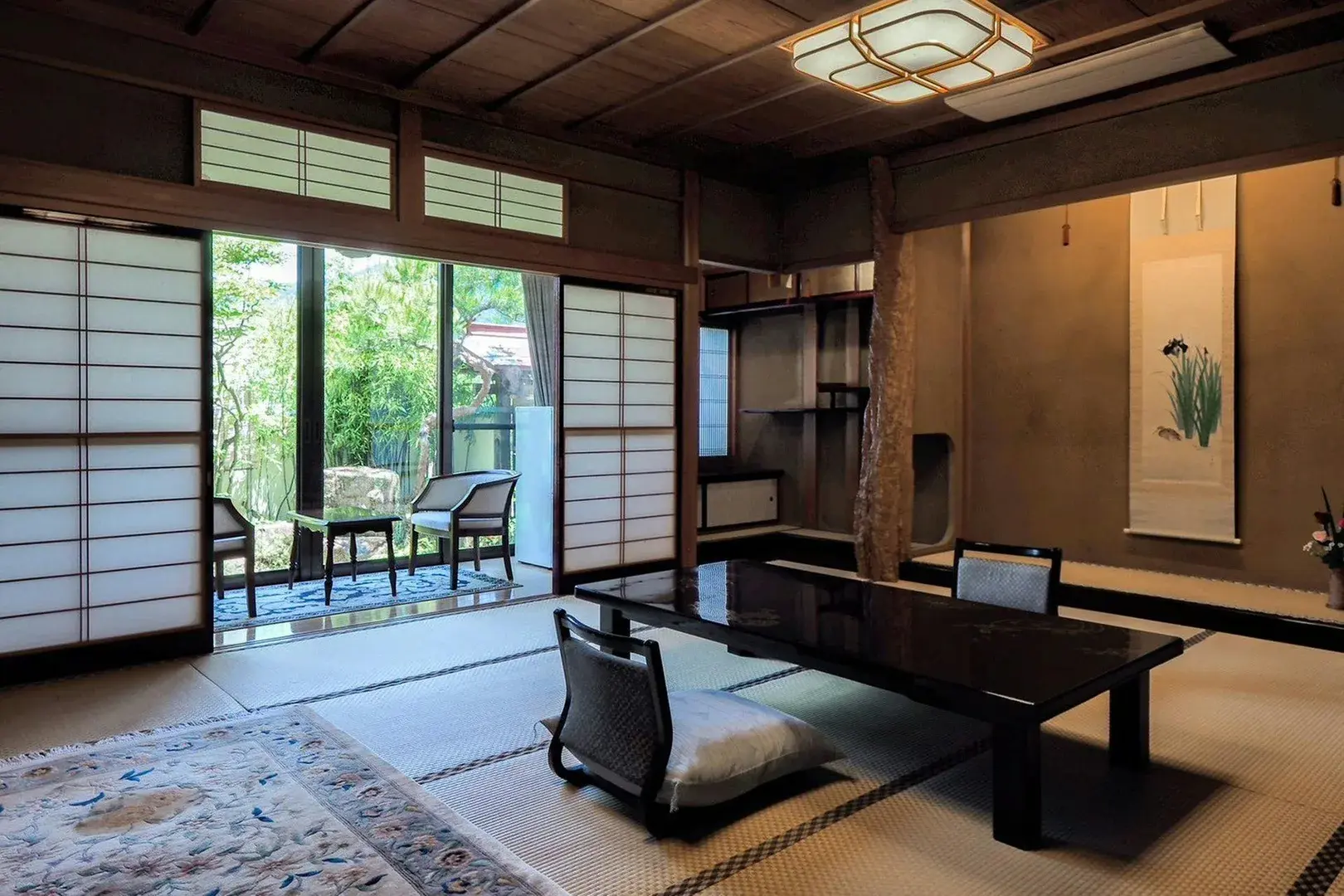 Garden-facing tatami room with iris hanging scroll and shoji screens at Yatsusankan