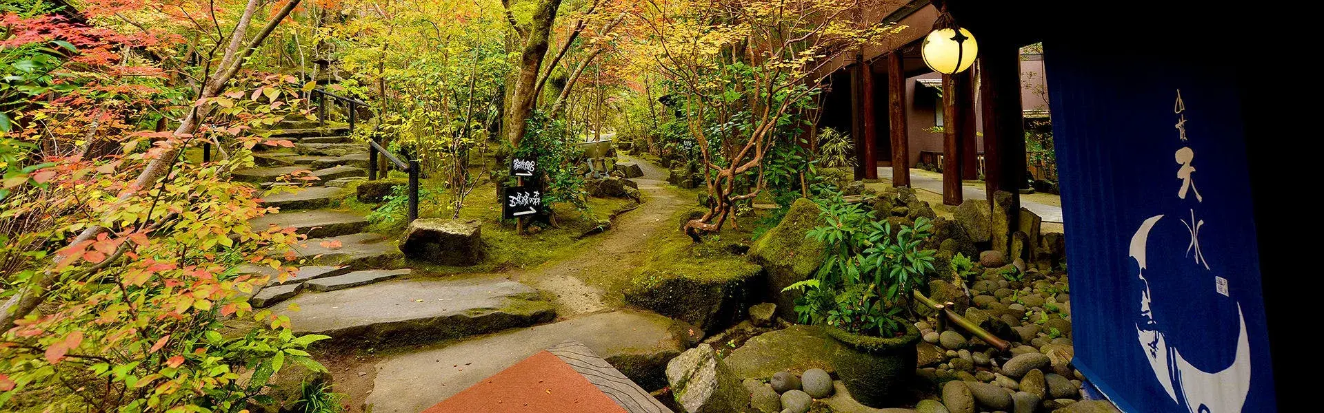 Sansou Tensui's moss-lined stone entrance path beneath autumn maples in Amagase