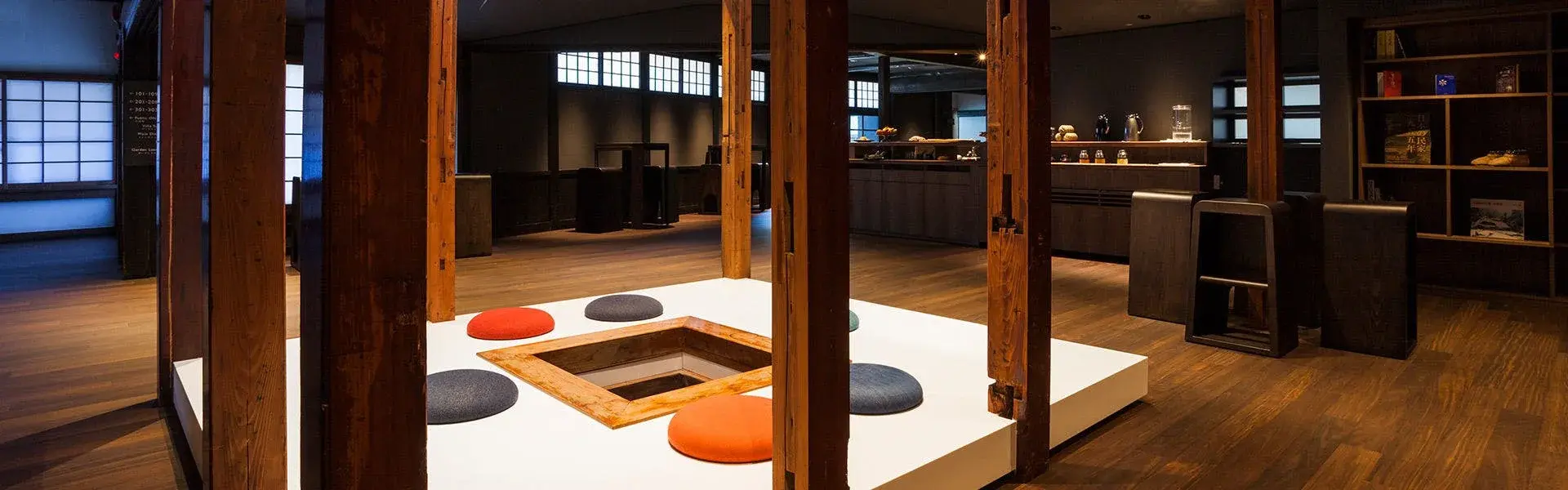 Ryugon's irori hearth lobby with colorful cushions set in dark timber surrounds