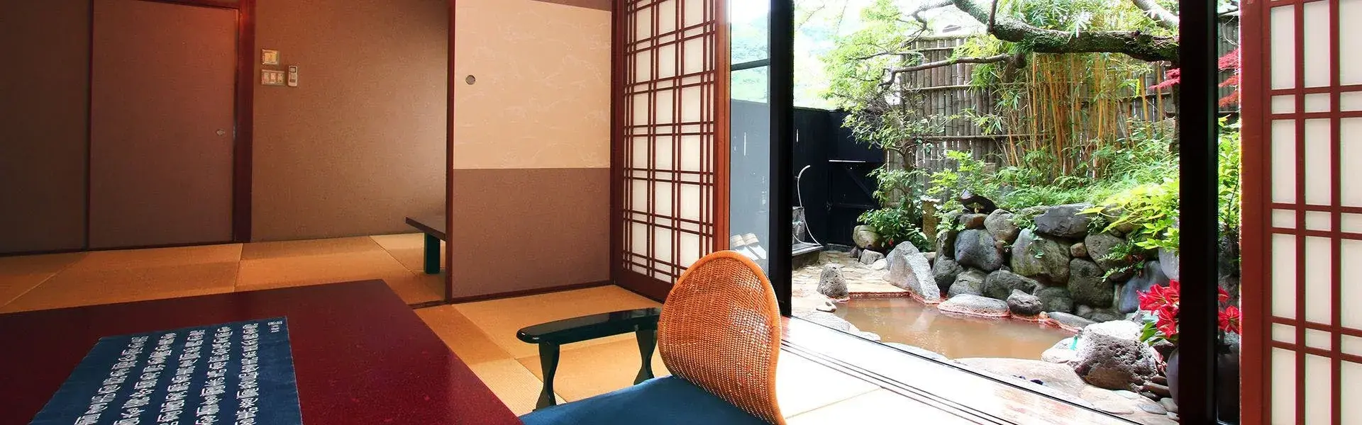 Hirayama Ryokan tatami room opening to private stone garden onsen, Iki