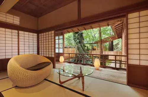 Tatami sitting room at Araya Totoan open to the garden, rattan chair and shoji screens