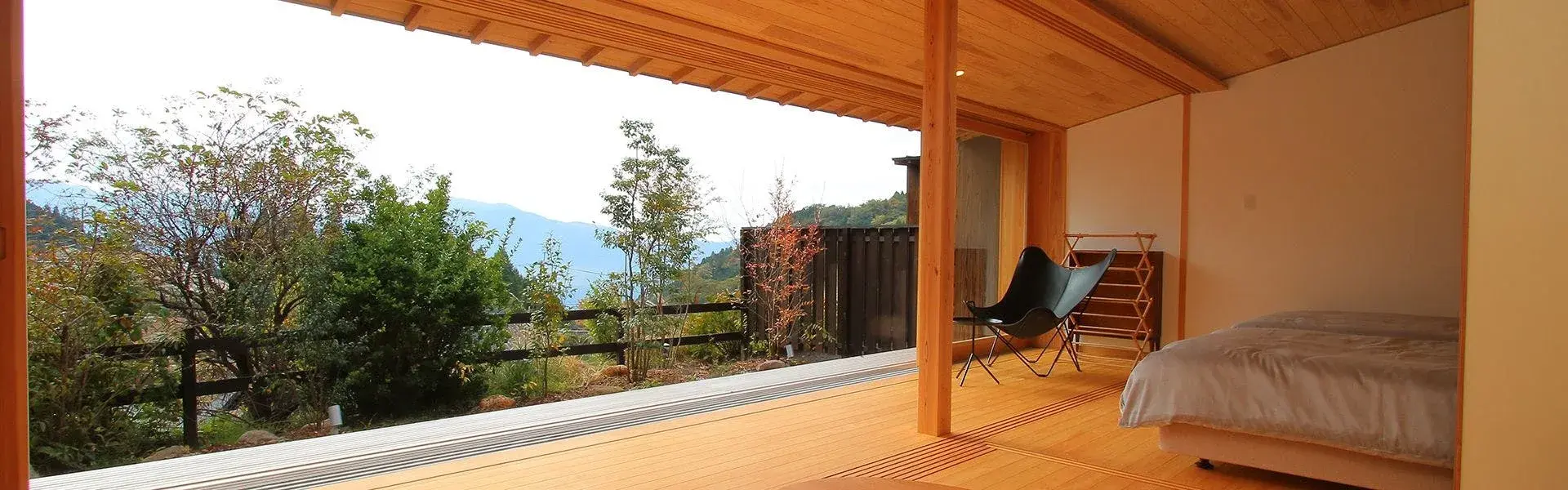 Jigoku Onsen Seifuso guest room opening onto forested hillside in Minamiaso
