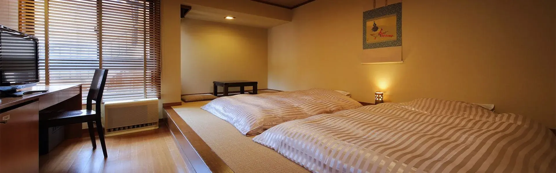 Futon bedding on raised tatami platform with hanging scroll, Kuhe Ryokan