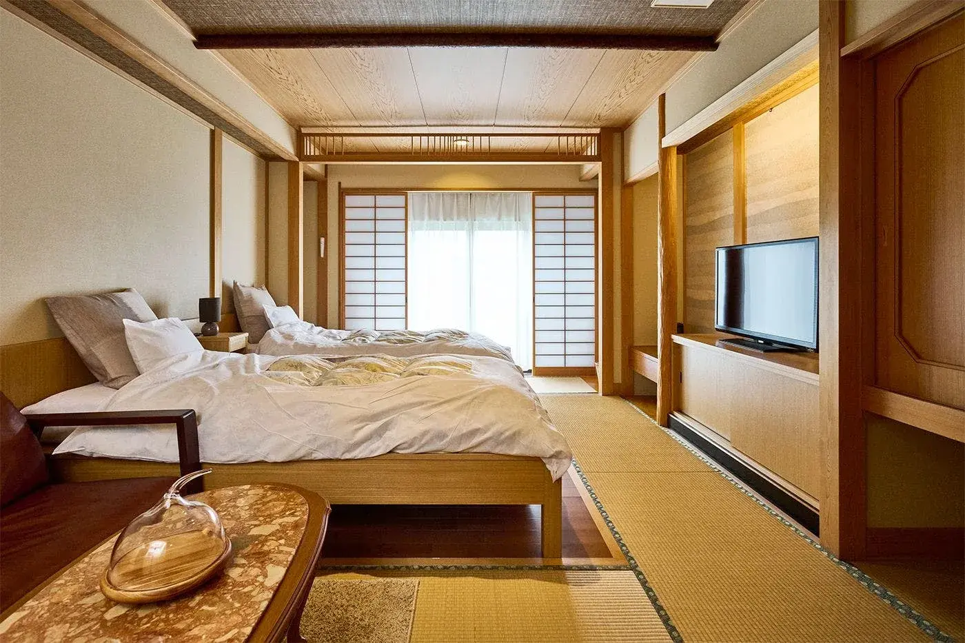 Tatami room with Western bed and shoji screens at Kappo Inn Taikanso in Higashi-Izu