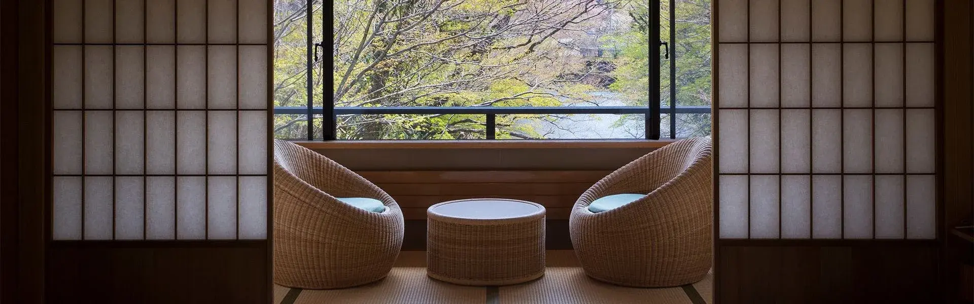 Wicker chairs before open shoji screens framing the Gohyakugawa gorge at Atami-so