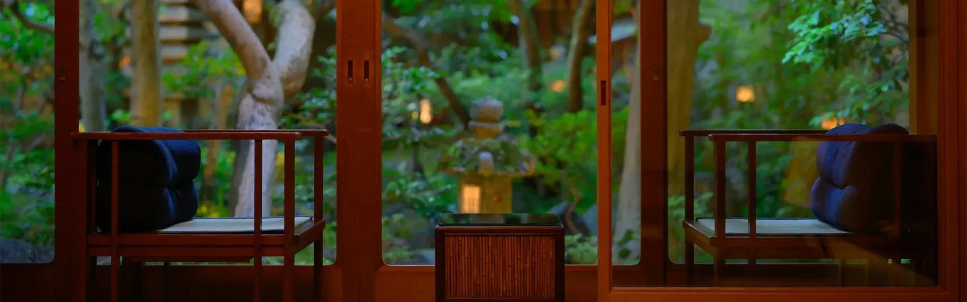 Evening garden view through shoji screens at Yoshikawa, stone lantern among trees