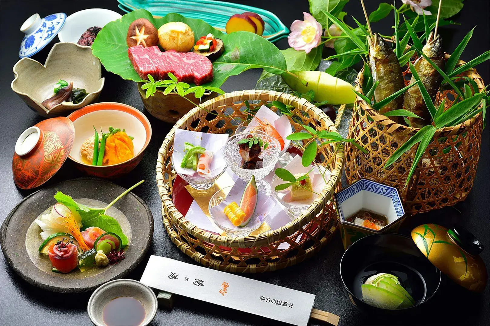 Kaiseki dinner spread with sashimi basket and seasonal small dishes at Kikunoyu