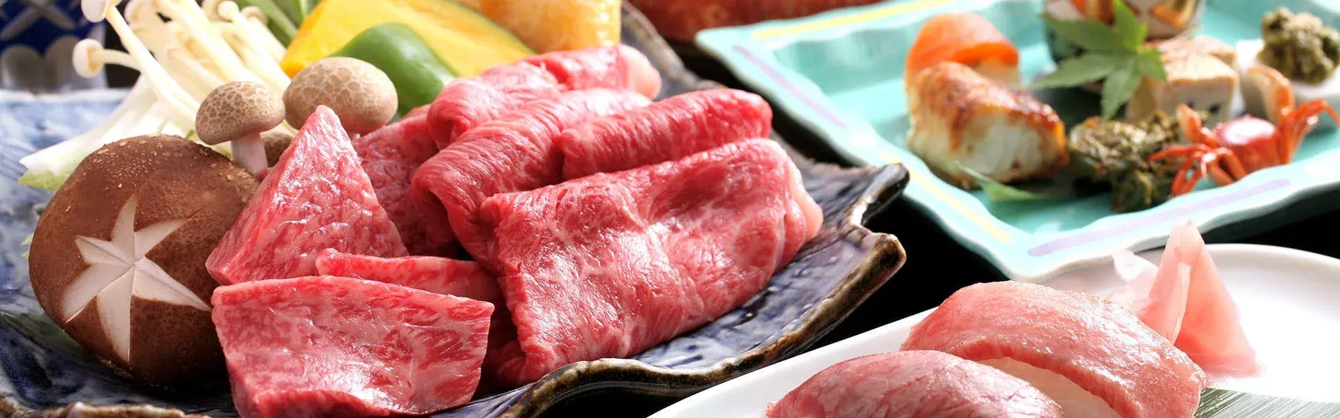 Wagyu beef and mushroom shabu-shabu spread on blue ceramic at Kutsuroginoya Yu