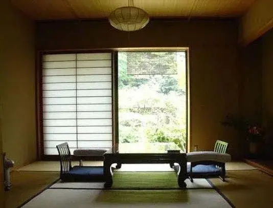 Shoji screens open onto garden greenery in a Nagayu tatami room