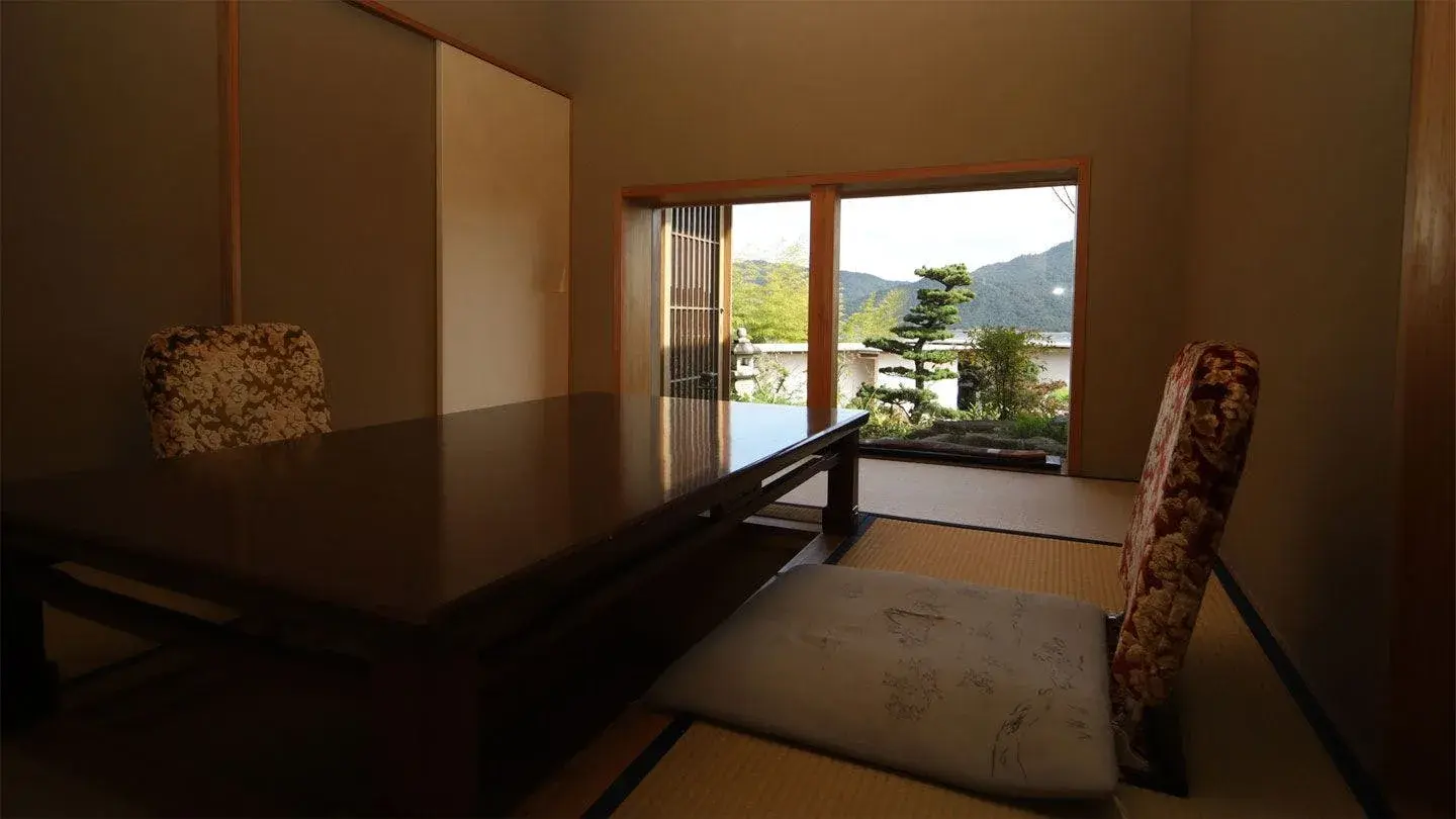 Tatami dining room with garden pine and mountain view at Hatago Sakura