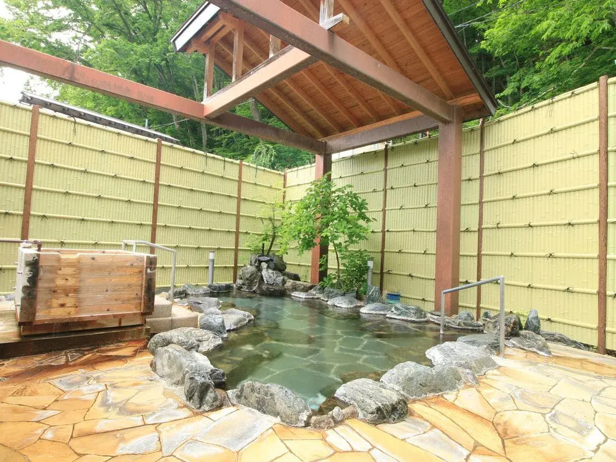 Kamiyashiki Taira no Takafusa's rotenburo stone bath enclosed by bamboo fence and summer foliage