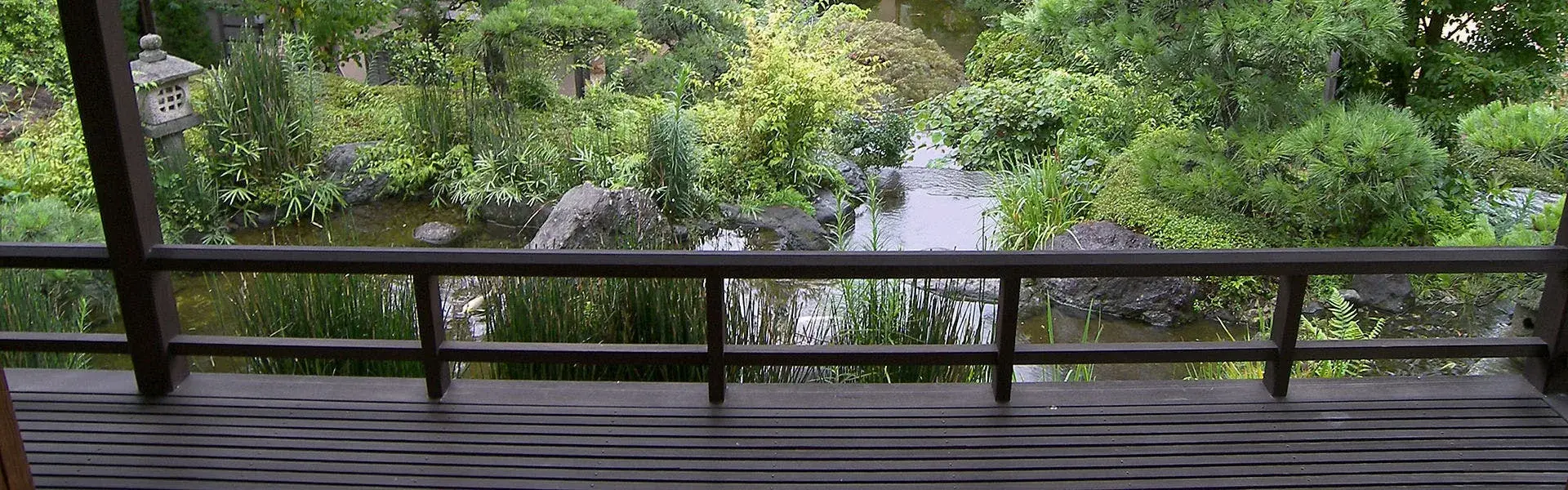 Wooden engawa overlooking the stone-lanterned koi garden at Sakuraoka Saryo, Atami