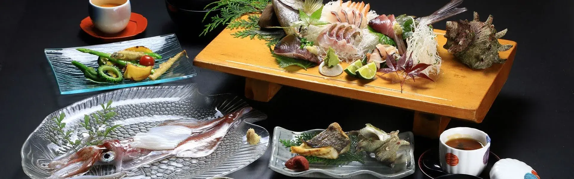 Iki seafood spread with whole fish sashimi and grilled courses on dark stone