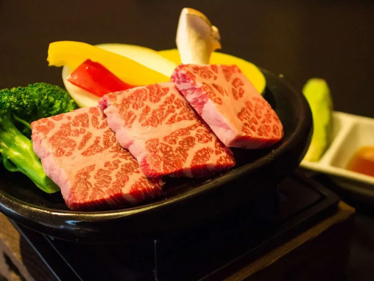 Marbled wagyu beef cuts on cast iron plate, Umegashima kaiseki dinner course