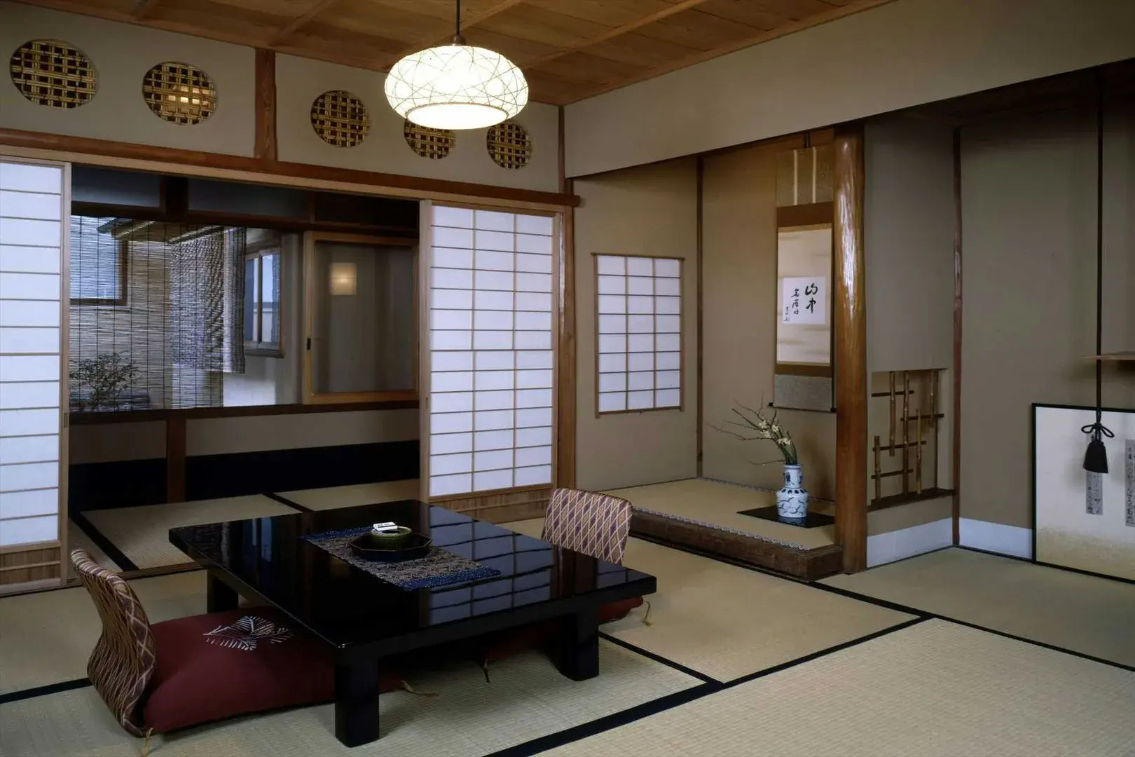 Sumiya Ryokan tatami room with shoji screens, lacquered table, and calligraphy scroll in tokonoma