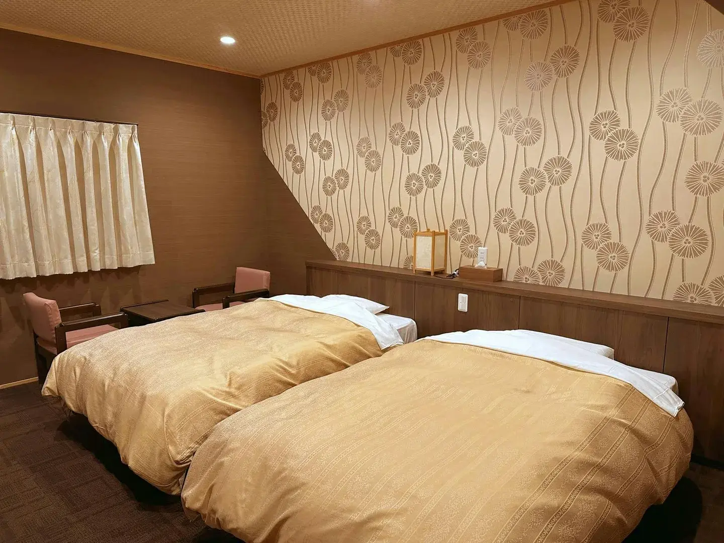 Twin bedroom with gold bedding and chrysanthemum-patterned wallpaper at Kamiyashiki Taira no Takafusa