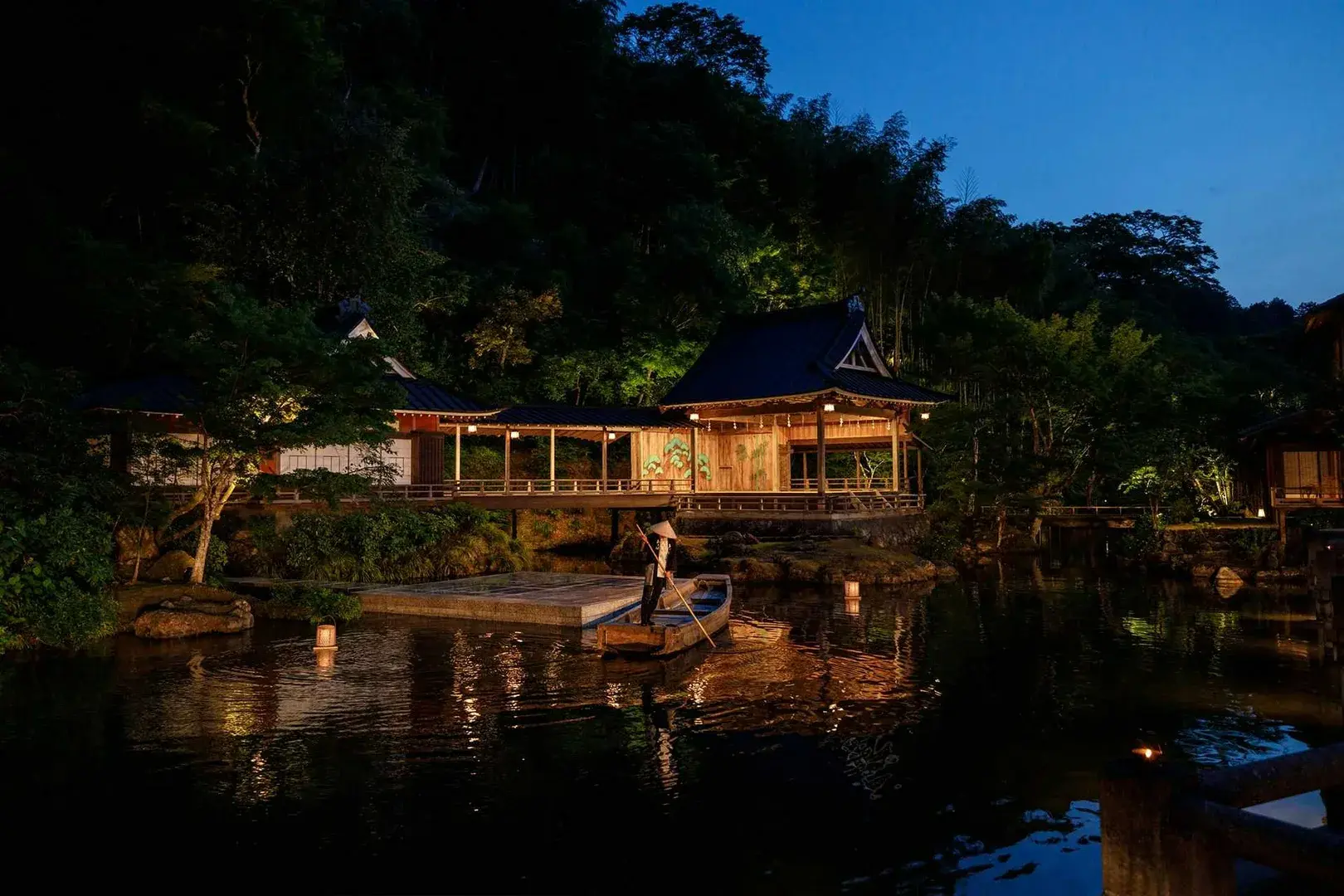 Gondolier crossing Asaba's garden pond at dusk, Noh stage pavilion glowing behind