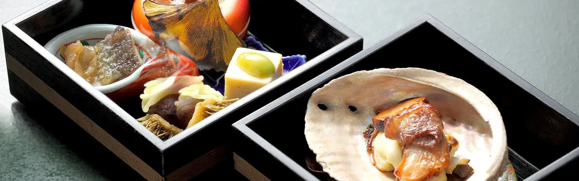 Kaiseki opening courses in lacquered boxes with grilled abalone on the shell at Hirosekan Hiten no Oto