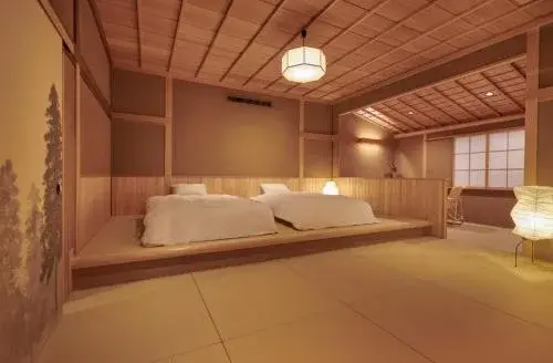 Araya Totoan tatami room with raised platform beds and cedar lattice ceiling