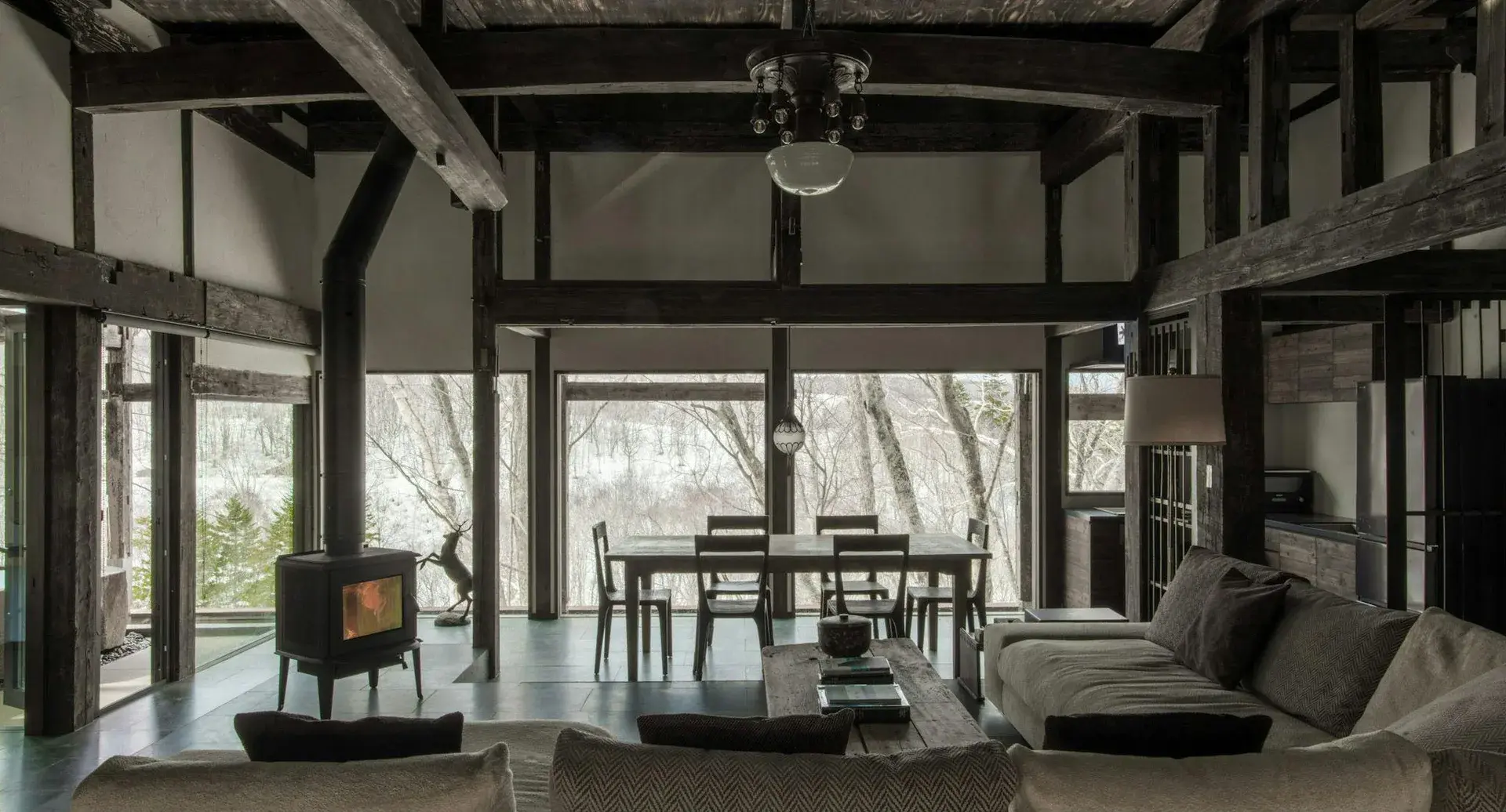 150-year-old timber frame kominka villa living room with wood stove in Kutchan