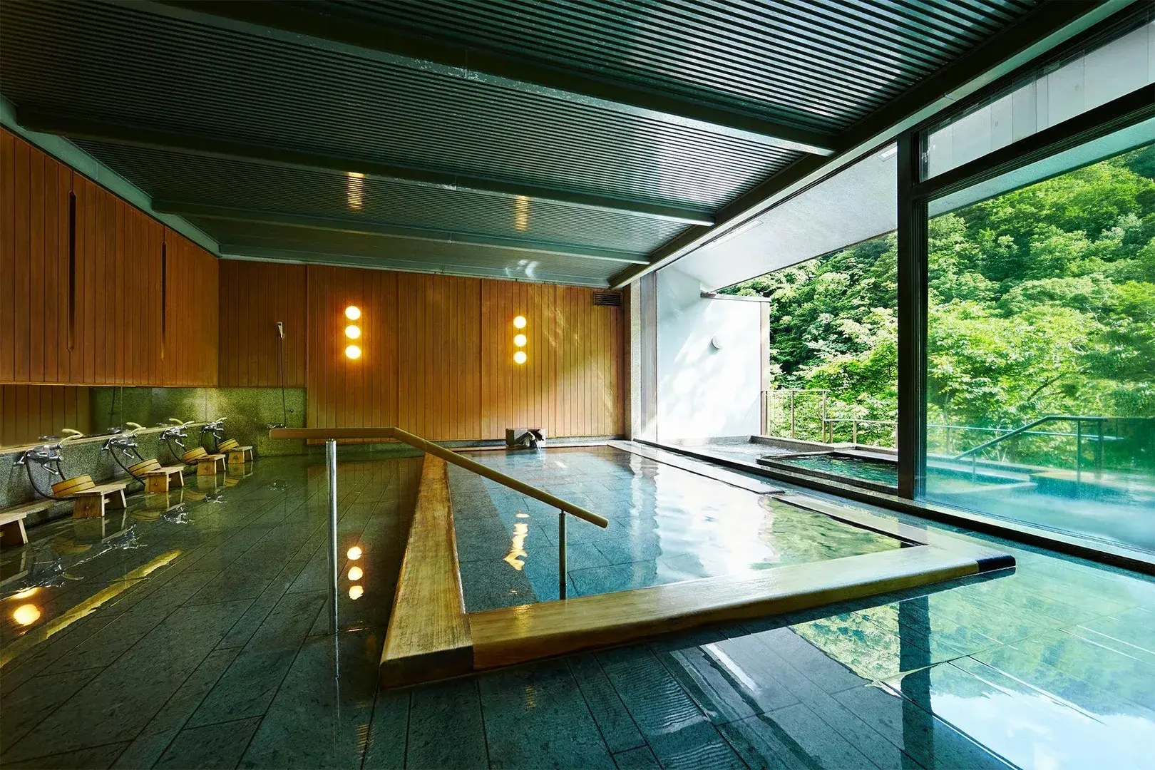 Yamada Onsen indoor bath with cedar paneling and summer forest-facing glass wall