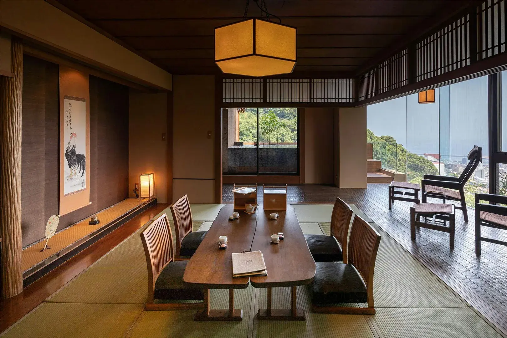 Tatami room at WA Tei Kazekomichi with rooster scroll, paper lantern, and Sagami Bay beyond the veranda